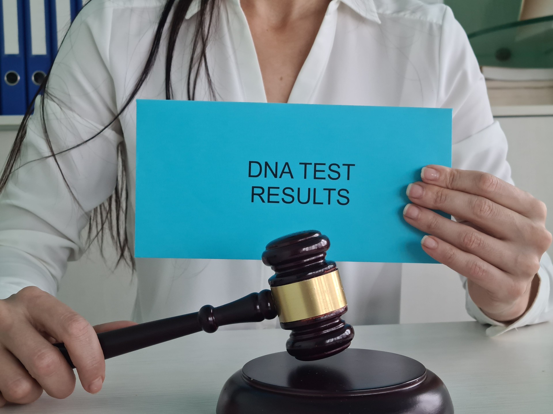 Woman Holding DNA Test Results in Front of Gavel