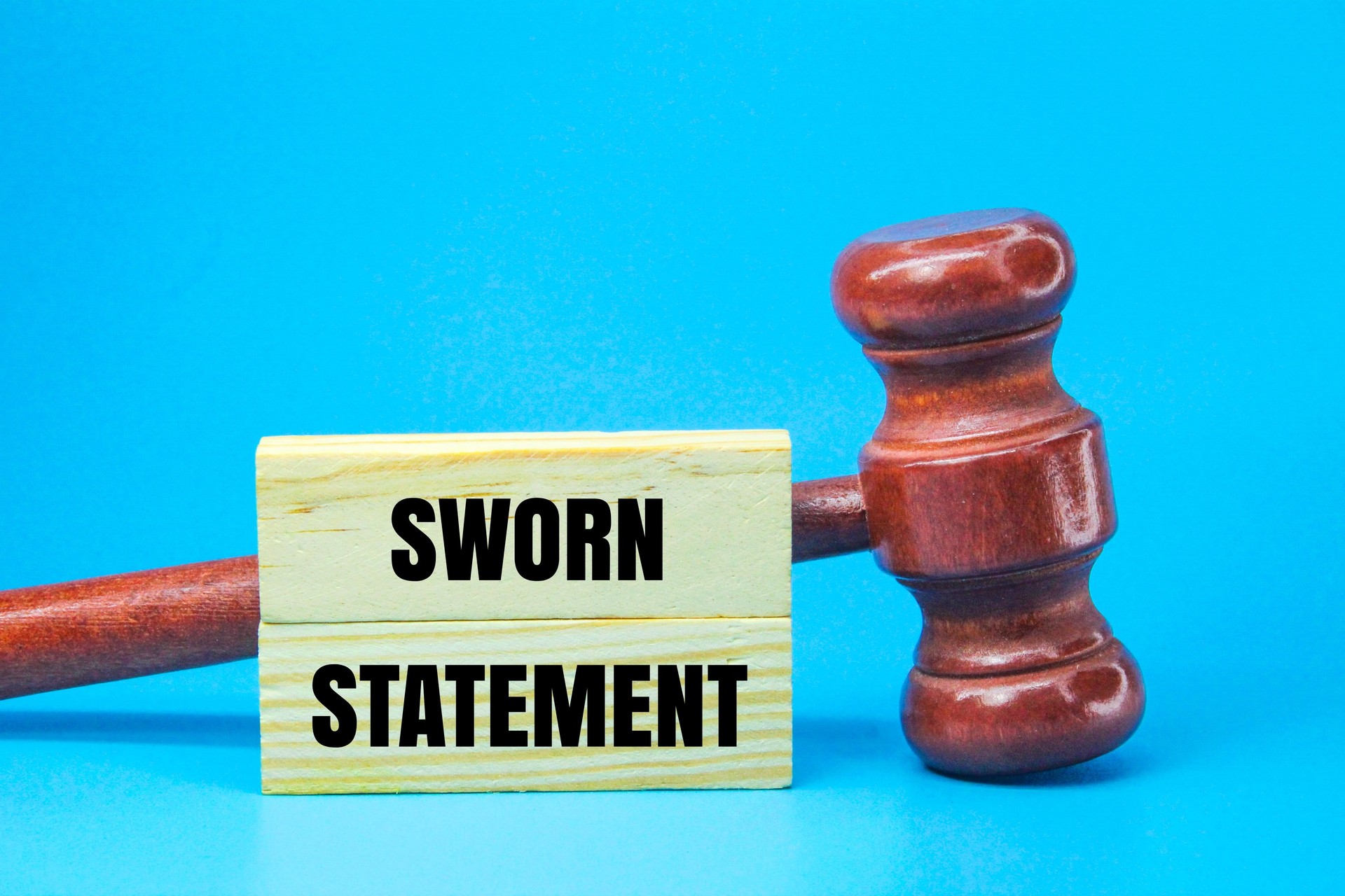 judge's gavel and stick with the word sworn statement. the concept of sworn statement or evidence of confession. concept of justice.